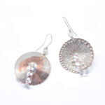 Large circular textured silver earrings with white and pink beaded detail