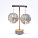 Large circular textured silver earrings with white and pink beaded detail