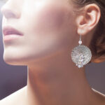 Large circular textured silver earrings with white and pink beaded detail