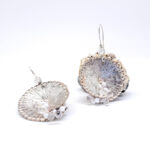 Large circular textured silver earrings with white and pink beaded detail