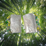 rectangular textured silver stud earrings with green beaded edging on tree background